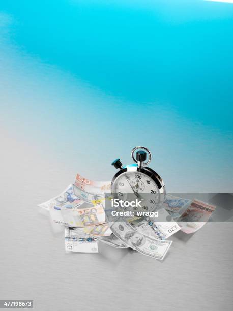 American European And British Currency Scattered Around A Stopwatch Stock Photo - Download Image Now