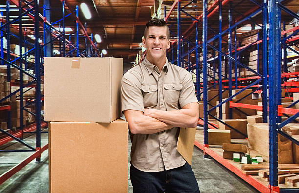 istock Smiling delivery person in warehouse 477203816
