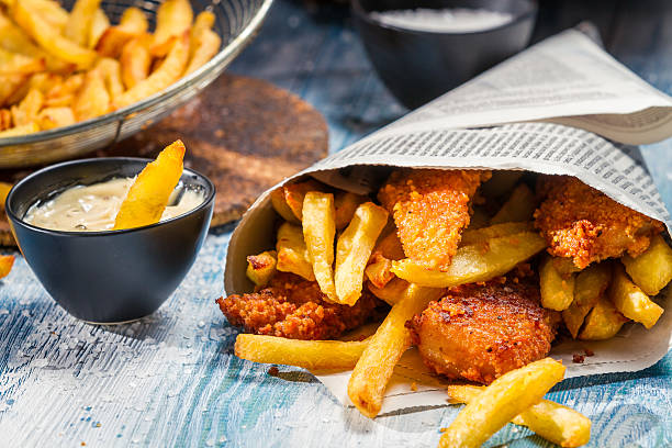 primer plano de cubos de pescado & que se sirve en el periódico - prepared sole fotografías e imágenes de stock