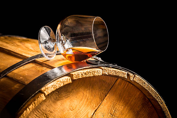 Glass of cognac on the vintage barrel stock photo