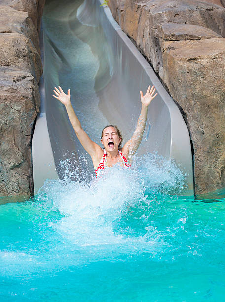 istock Woman Enjoying a wet ride down Water Slide 477206710
