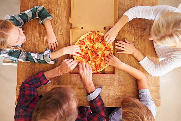 istock Family eating pizza together, overhead view 477207730