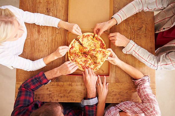 istock Friends sharing a pizza together, overhead view 477207736
