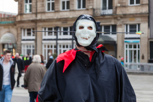 Cologne, Germany - March 03, 2014: unidentified man with a mask and a cloak has an  arrow through the head at carnival in Cologne