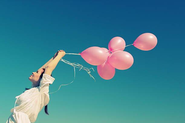 istock woman holding pink balloons 477210553