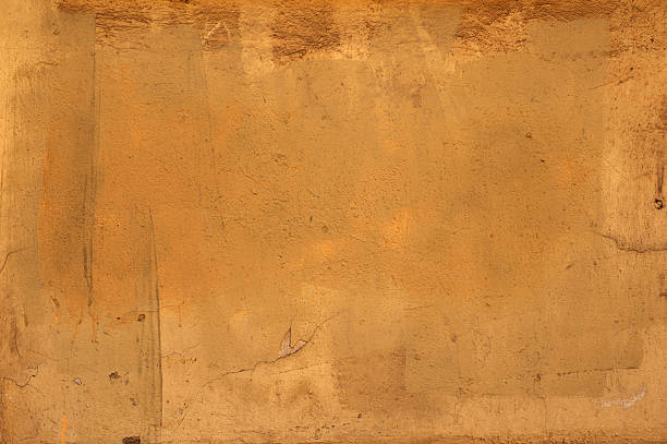 istock Texture of old wall covered with yellow stucco 477210624
