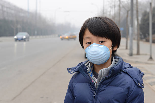 asiatische junge mit mund maske gegen luftverschmutzung (peking) - night beijing city asia stock-fotos und bilder