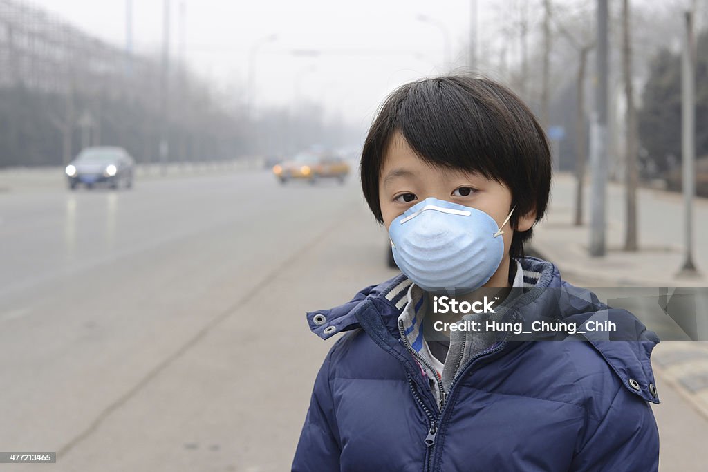 Asian menino usando máscara boca contra a poluição atmosférica (Beijing) - Foto de stock de Cidade royalty-free