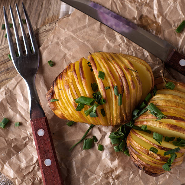 istock Sliced baked potatoes over wooden background. 477214162