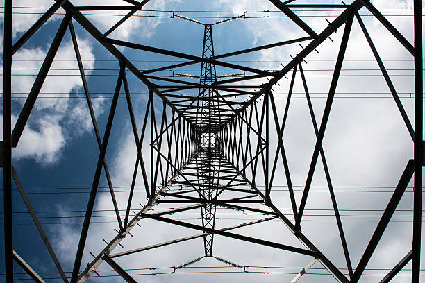 istock Electricity pylon from low perspective with white clouds on background 477217306