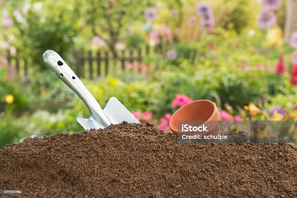 Humus soil - Hand Shovel -Leerer clay pot Humus soil - Hand Shovel -Leerer clay pot, in the background the garden Dirt Stock Photo