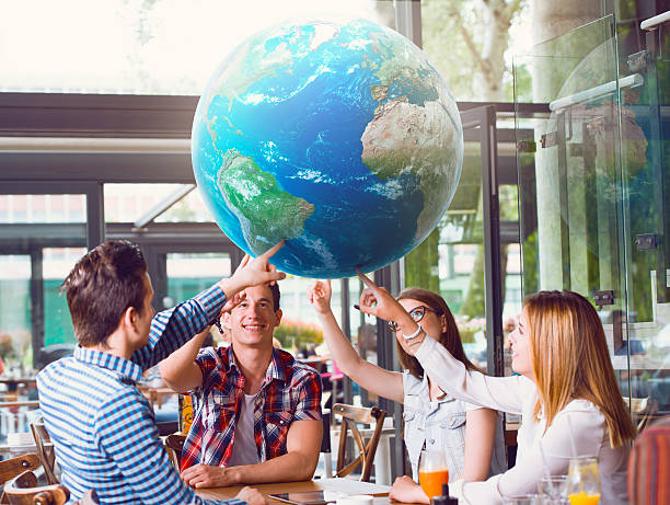 Group of young people pointing at planet Earth stock photo