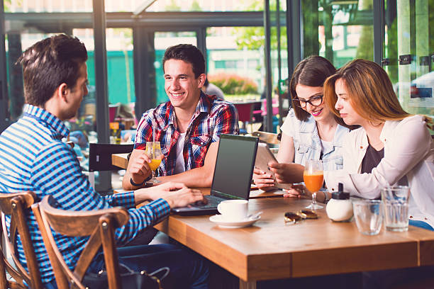 istock Group of young people sitting at a cafe, talking 477221050