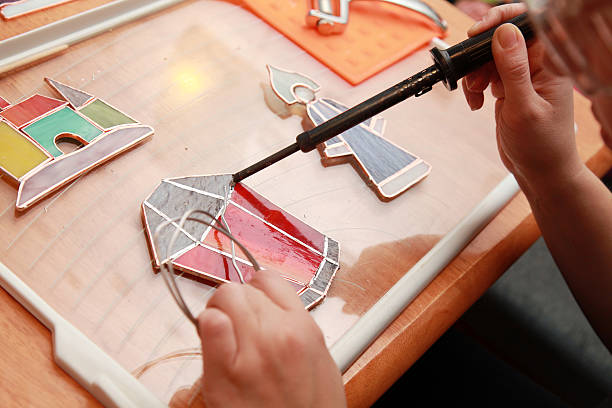 istock Stained glass maker works with red lamp souvenir 477225377
