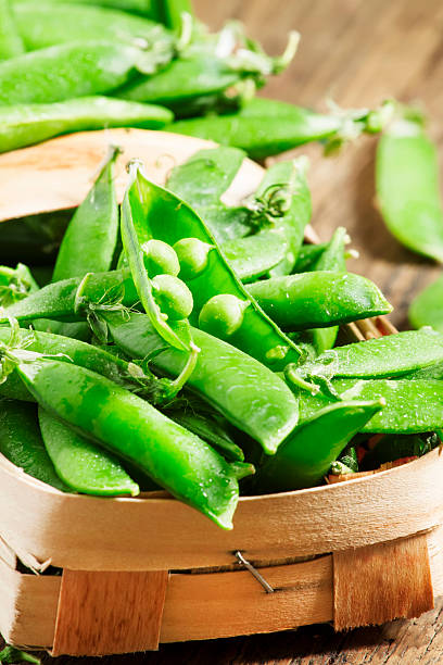 istock Young green peas on a wooden table 477238600