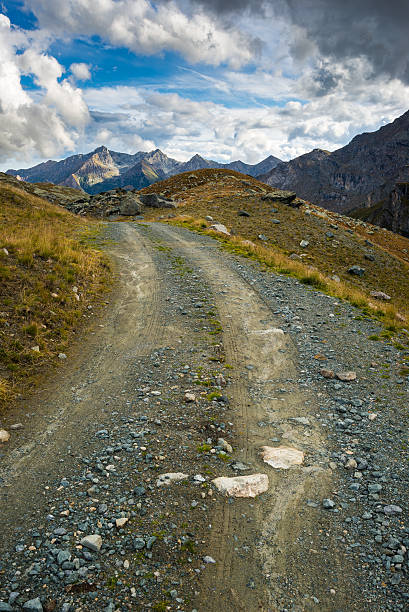 istock Dirt road in scenic alpine landscape and dramatic sky 477239162