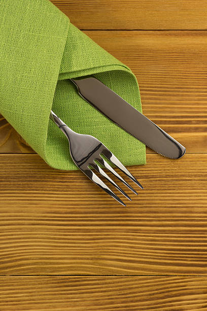 istock knife and fork at napkin on wood 477239484