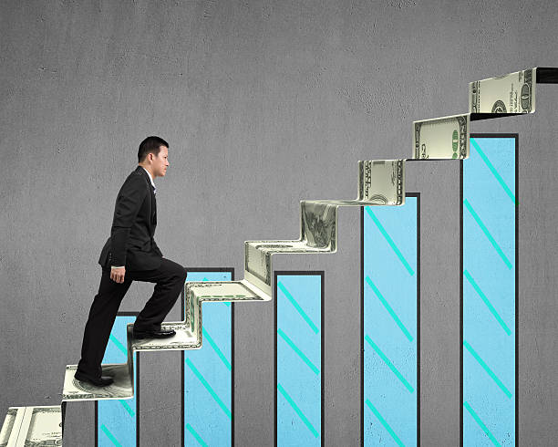 istock businessman walking on money stairs with chart 477241667