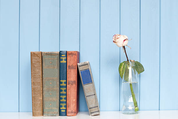istock Books pile and white rose in the bottle 477249644
