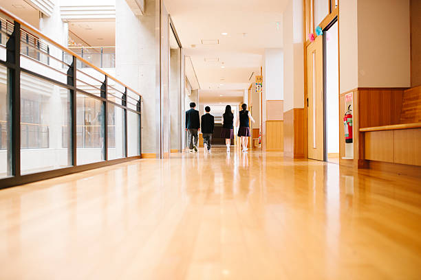istock Japanese high school. Four students walk through corridor, rear view 477252502