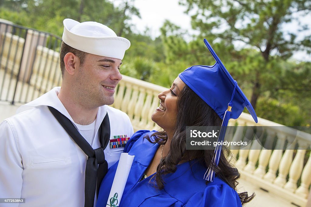 Confident young woman graduates A young woman of indian ethnicity looks confidently at her marine boyfriend on her graduation day.  Perhaps they are discussing her bright future Military Stock Photo