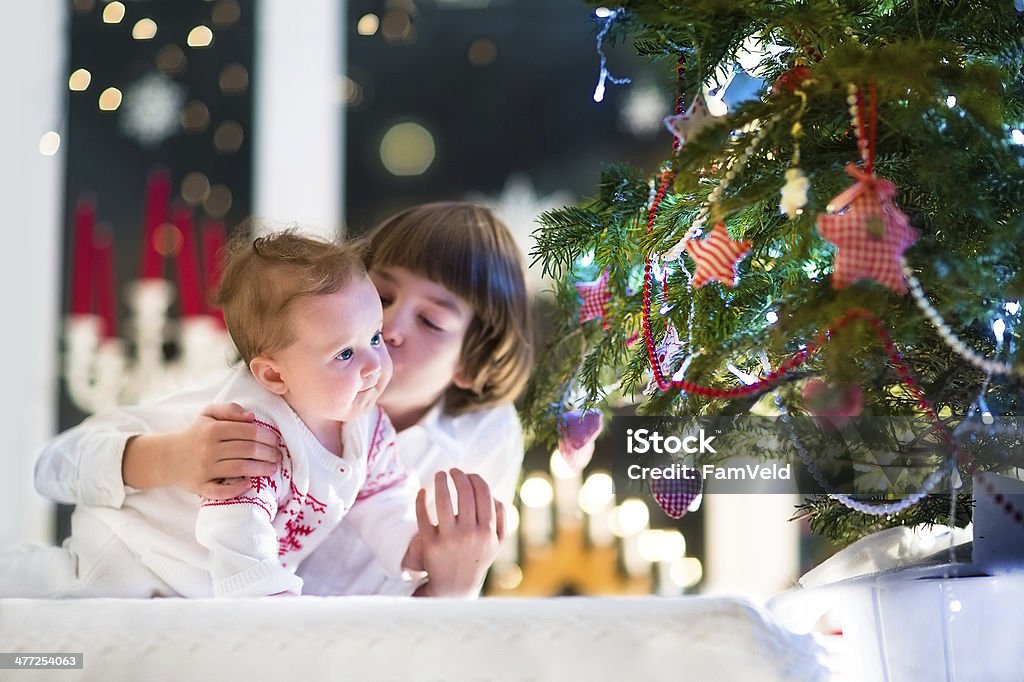 Irmão e irmã seu bebê brincando juntos na árvore de Natal - Foto de stock de Alegria royalty-free