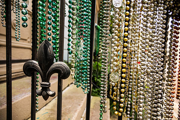 Mardi Gras Beads Colorful collections of Mardi Gras bead hanging from a rail with a fleur de lis new orleans fleur de lis stock pictures, royalty-free photos & images
