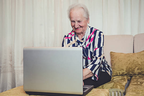 istock Senior woman smiling and using laptop 477257910