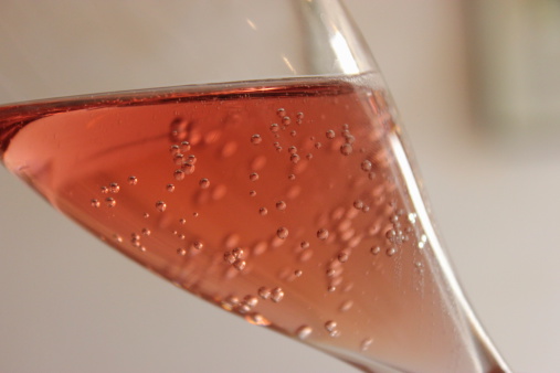 The image is a close up shot of a glass of sparkling wine, in this case Champagne.
