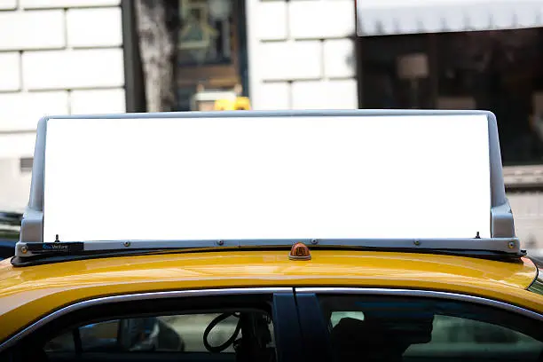 White blank billboard on the taxi roof. Yellow cab in New York City.
