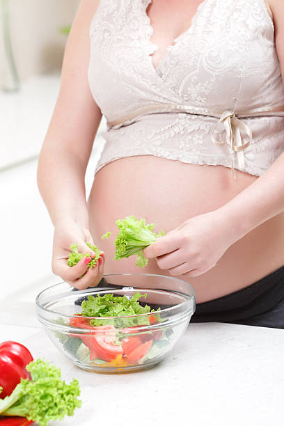 istock Pregnant woman cooking salad 477275802