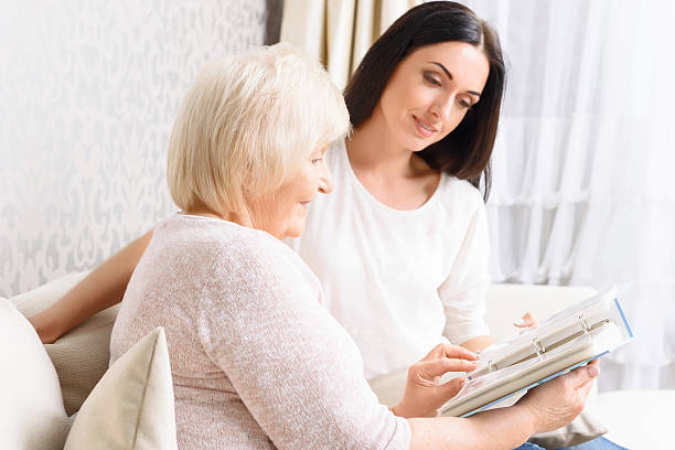 istock Grandmother with her daughter holding book 477276490