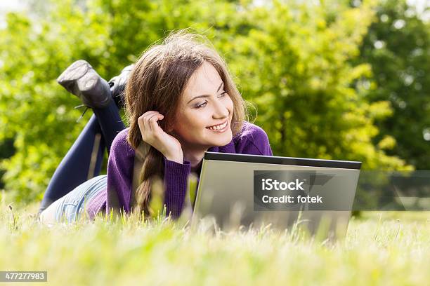 Mujer Joven Usando Una Computadora Portátil En El Parque Foto de stock y más banco de imágenes de Acostado