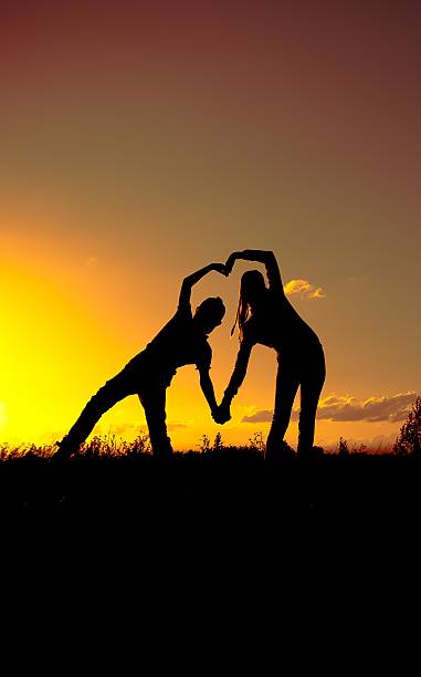 dos silueta al atardecer,, una declaración de amor - siluete fotografías e imágenes de stock