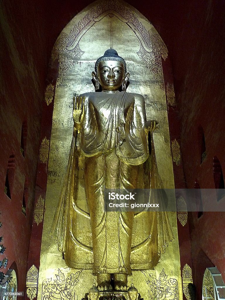 Standing Buddha, Ananda temple - Bagan Standing Buddha (Kakusandha) north facing inside of Ananda temple, on of the main temples of Bagan . There are four standing Buddhas adorned with gold leaf and each Buddha image faces a direction. Ananda Temple Stock Photo