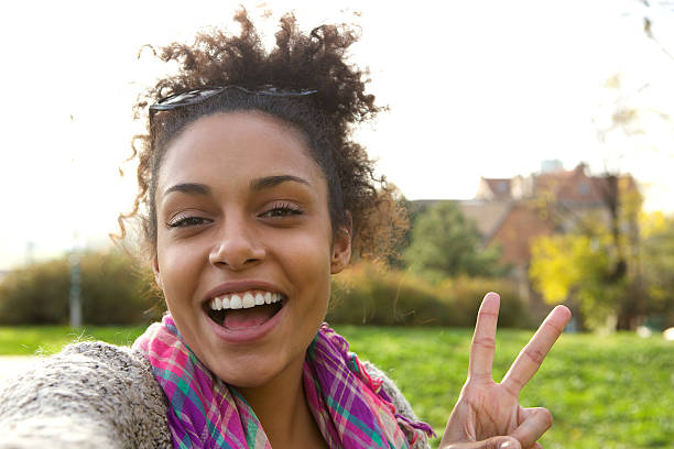 istock Happy young woman with peace sign 477296512