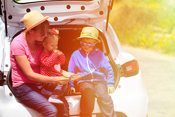 istock family looking at map while travel by car 477296858