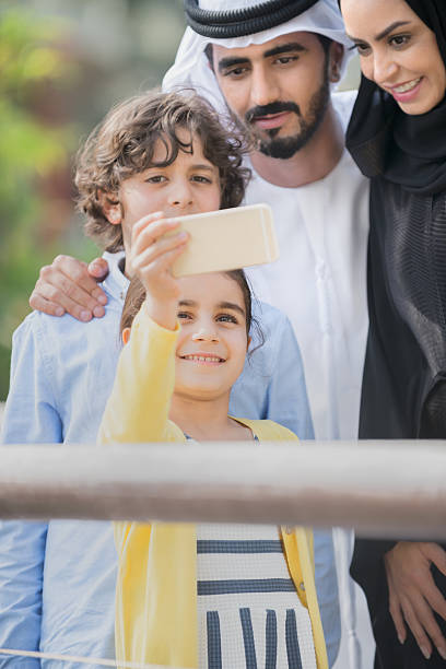 istock Young Girl Taking Selfie with Traditionally Dressed Middle Eastern Family 477301996