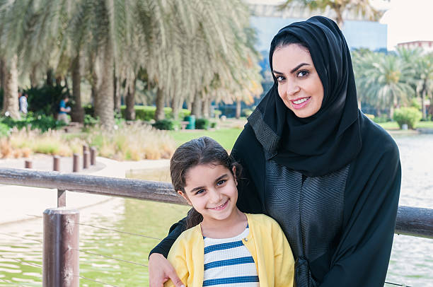istock Traditionally Dressed Arab Mother and Young Daughter Smiling at Camera 477301998