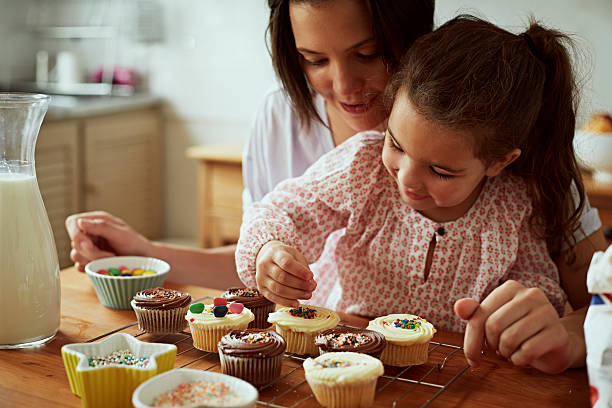 mother and daughter baking - looks back stock-fotos und bilder