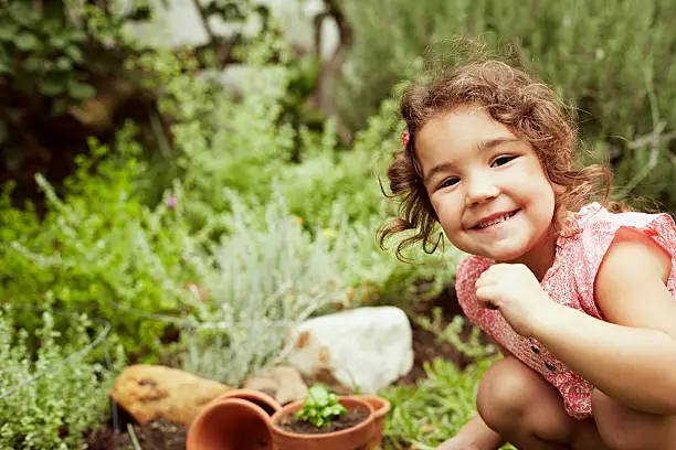 Portrait of little smiling girl gardening