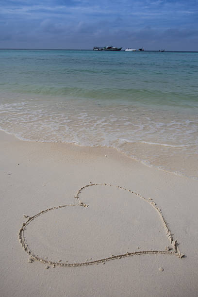 istock hearts drawn on the sand of a beach 477315178