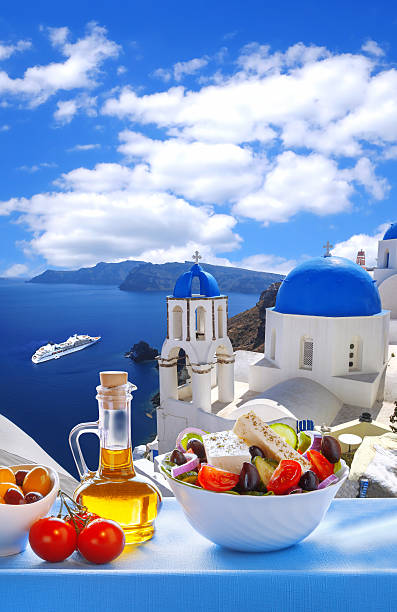 Greek salad on Santorini island, Greece Greek salad on Santorini island against famous churches in Oia, Greece table ledge stock pictures, royalty-free photos & images