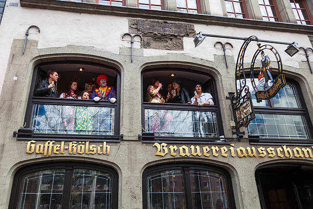Cologne, Germany - March 03, 2014: unidentified spectators in the window of the Gaffel brewery pub at the Rose Monday parade in Cologne