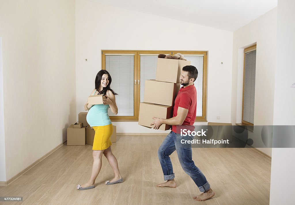 Young couple Young pregnant couple is moving into new house with lot of boxes. Adult Stock Photo