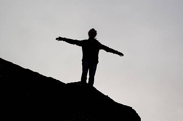 istock Black silhouette of a boy with open arms 477329305