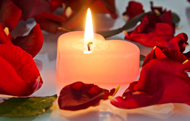 istock burning candle in rose petals 477330931