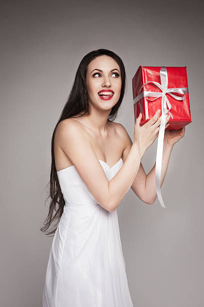 istock Smiling beautiful woman holding gift 477330963