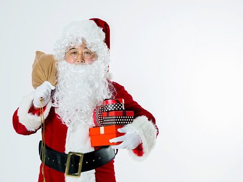 santa claus holding sack of presents isolated on white background.