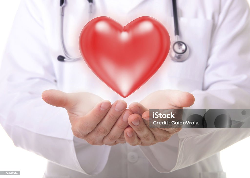 Maschio medico mostrando un cuore rosso - Foto stock royalty-free di Medico